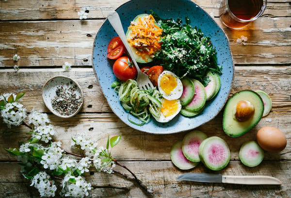 A keto-friendly plate of avocado, egg and fresh vegetables