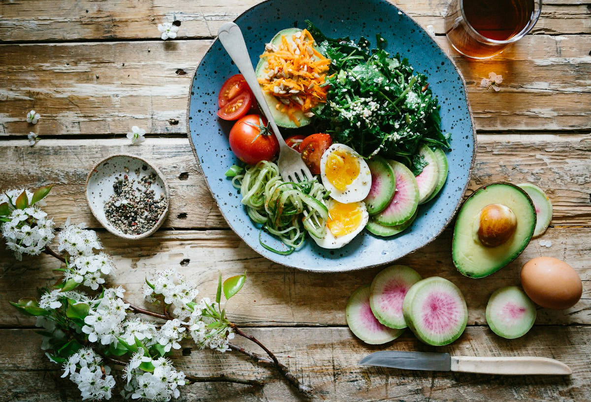 A keto-friendly plate of avocado, egg and fresh vegetables