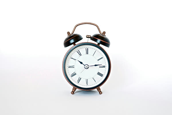 A classic alarm clock on a white background, representing fasting windows