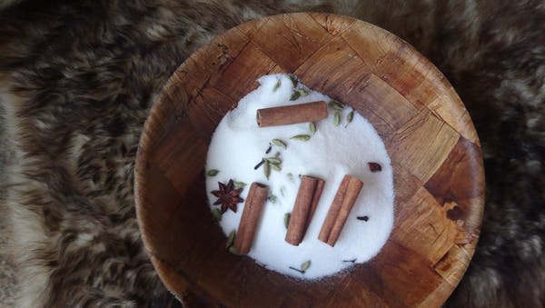 A wooden bowl of pale sweetener with cinnamon and spices