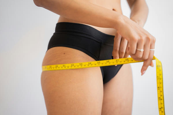 A measuring tape around the waist, representing weight management