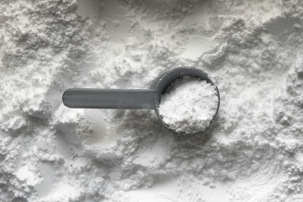 A measuring scoop of fine white monk fruit powder
