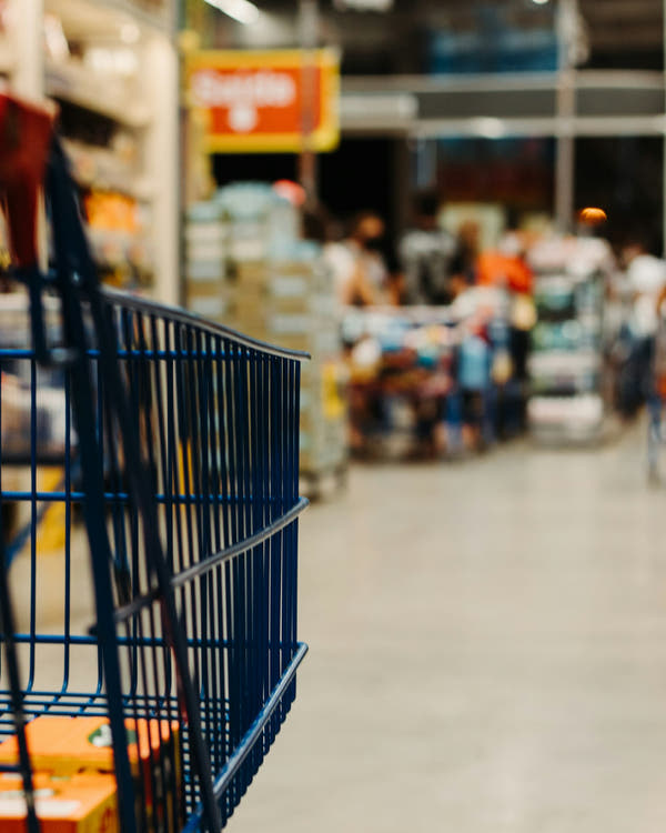 A shopping trolley in a bright supermarket aisle