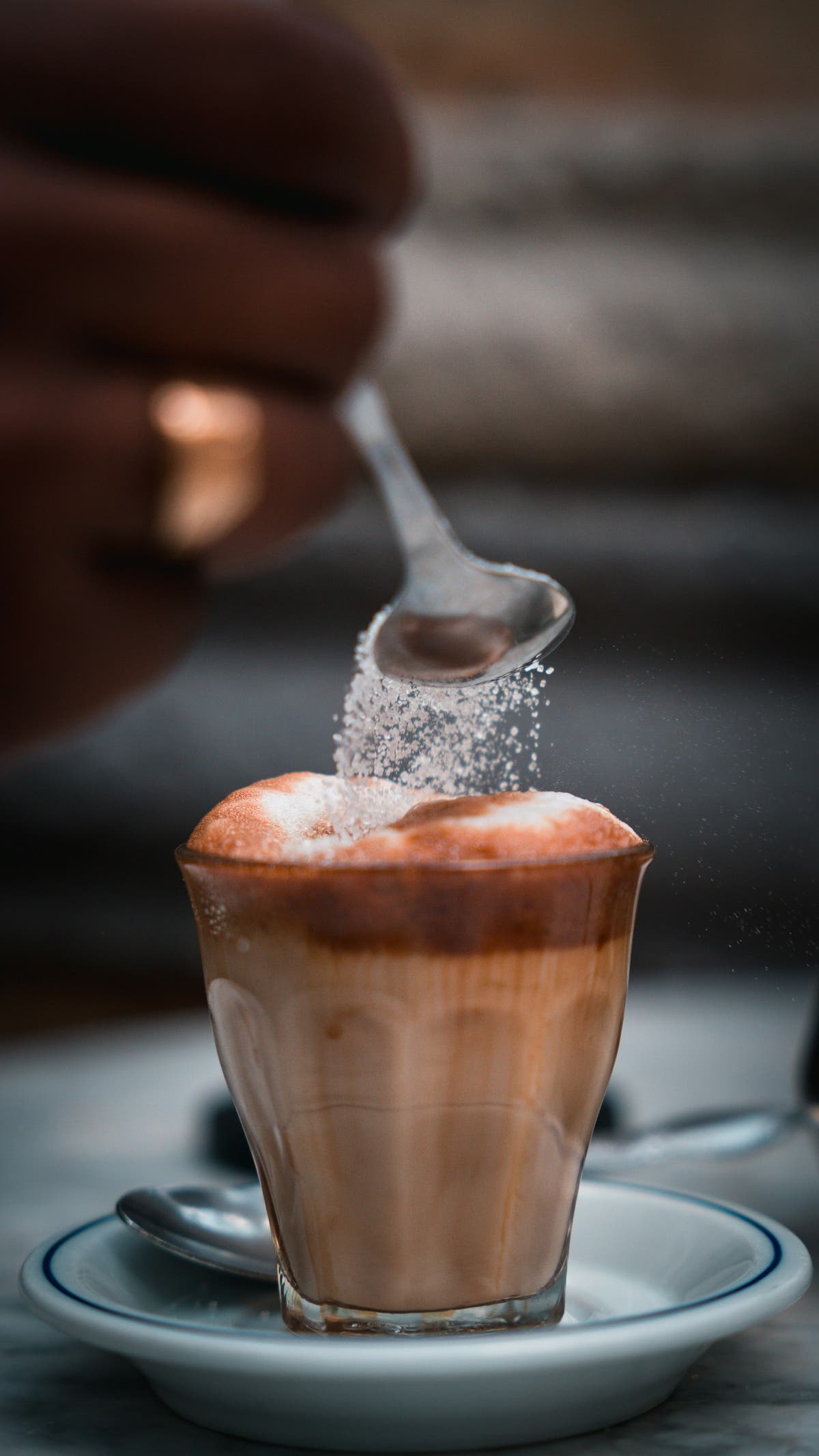 A spoonful of fine sweetener being sprinkled over a dessert