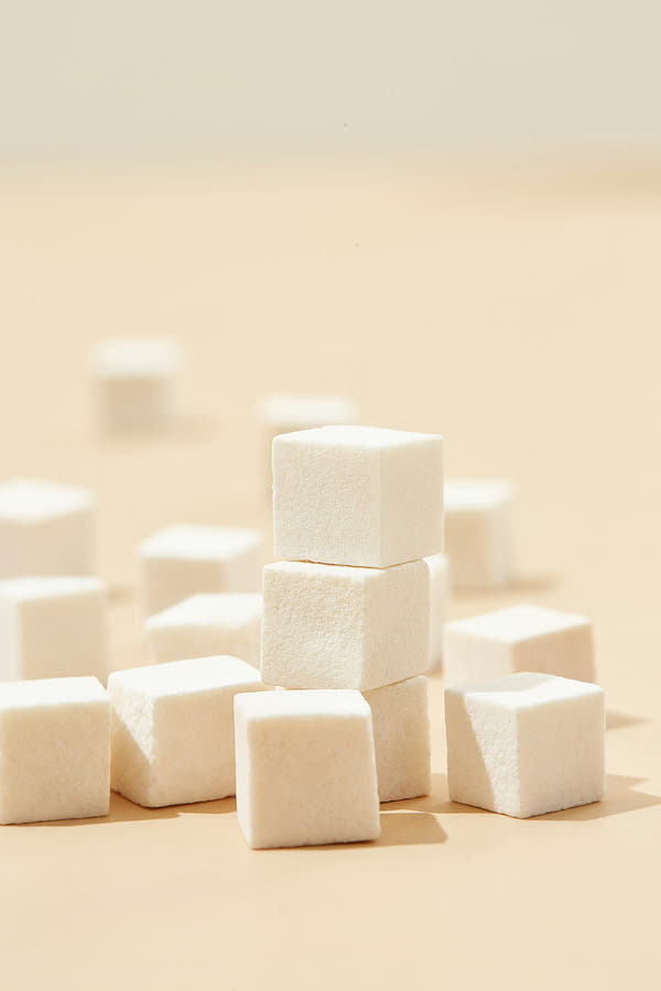Stacked white sugar cubes on a soft neutral background