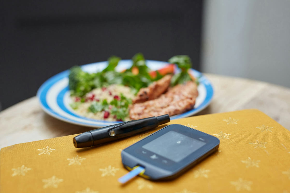A healthy plate of food beside a blood glucose meter