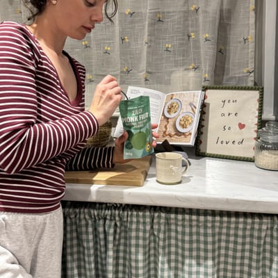 Rebecca spooning Zilch monk fruit sweetener from the pack in her kitchen